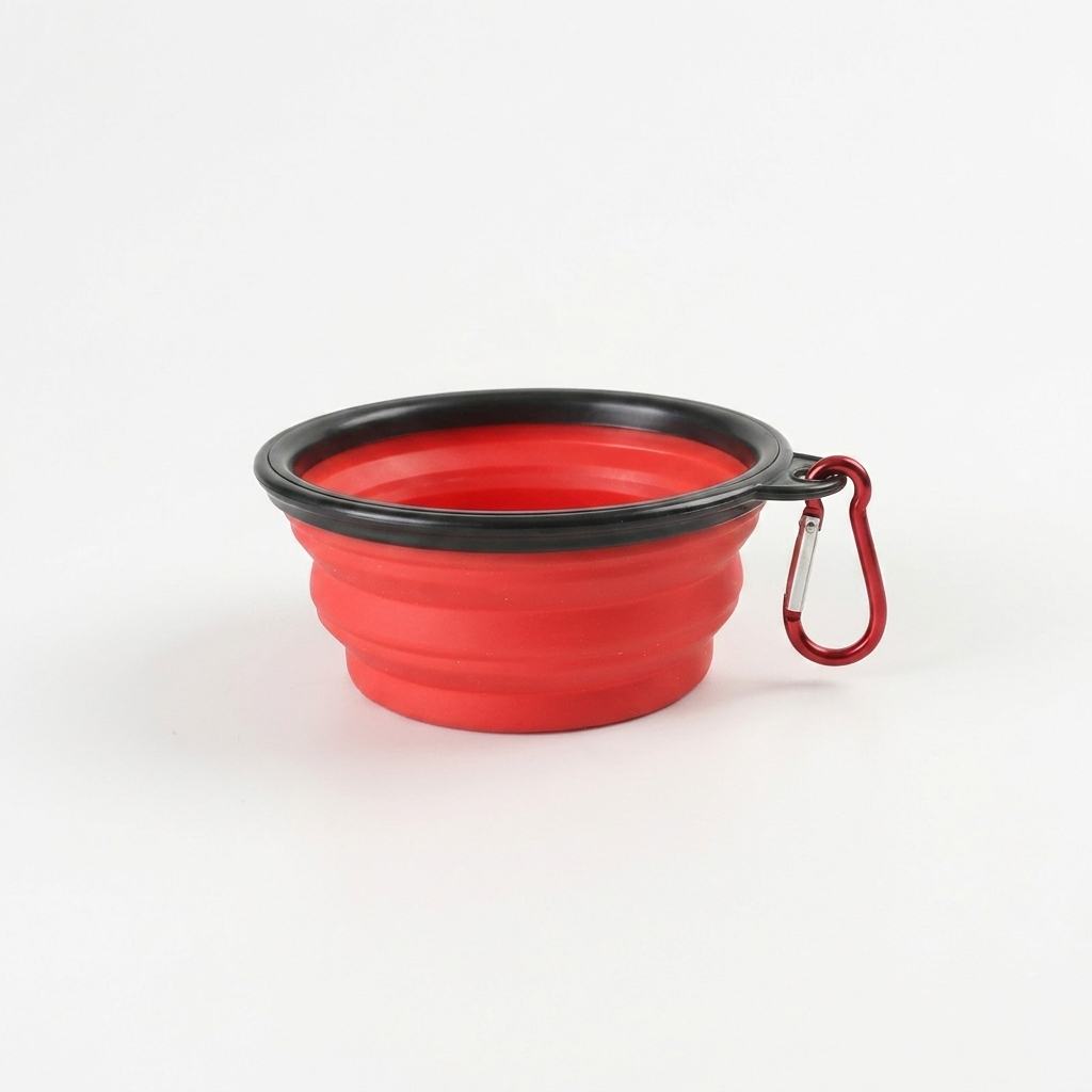 Red silicone dog bowl with black rim and carabiner on a white background